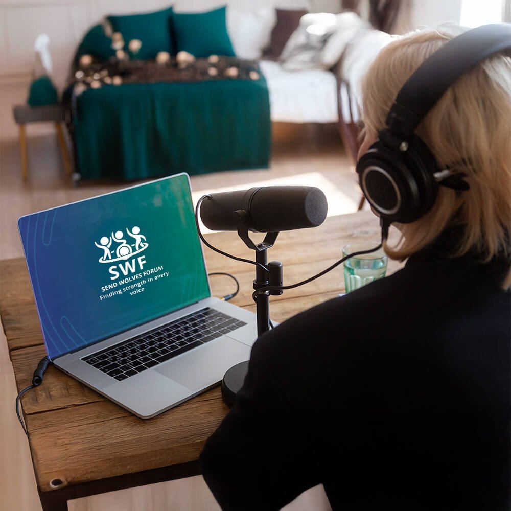A person wearing headphones speaking into a microphone at a desk, recording or hosting a session on a laptop displaying the “SWF Send Wolves Forum” logo in a home setting.